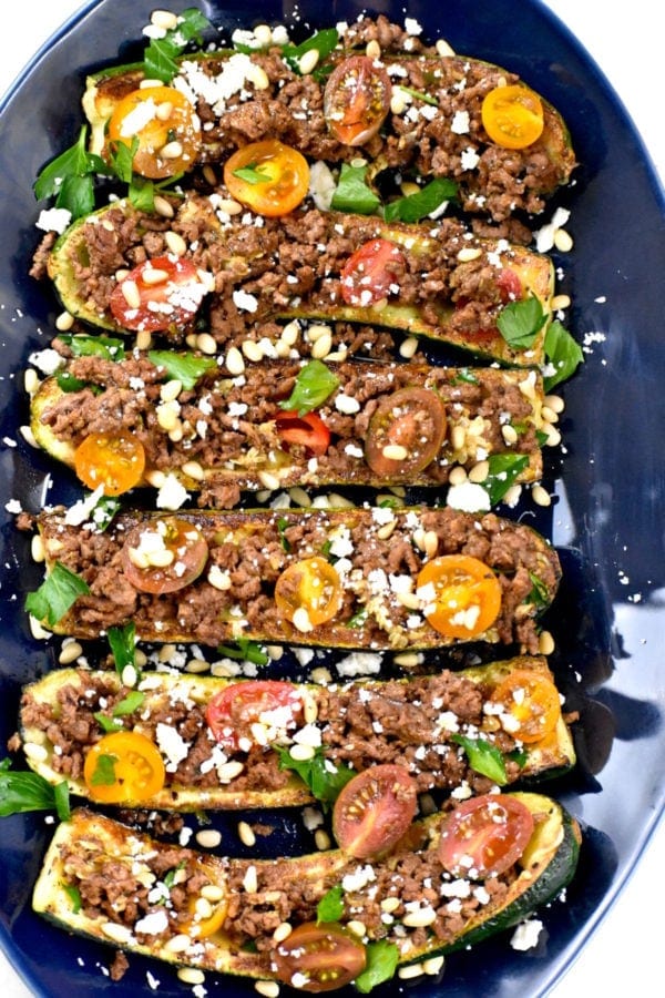 Mediterranean Zucchini Boats with Zucchini Halves Stuffed with Ground Beef, Tomatoes, Pine Nuts, Basil, and Feta Cheese, Drizzled with Oil