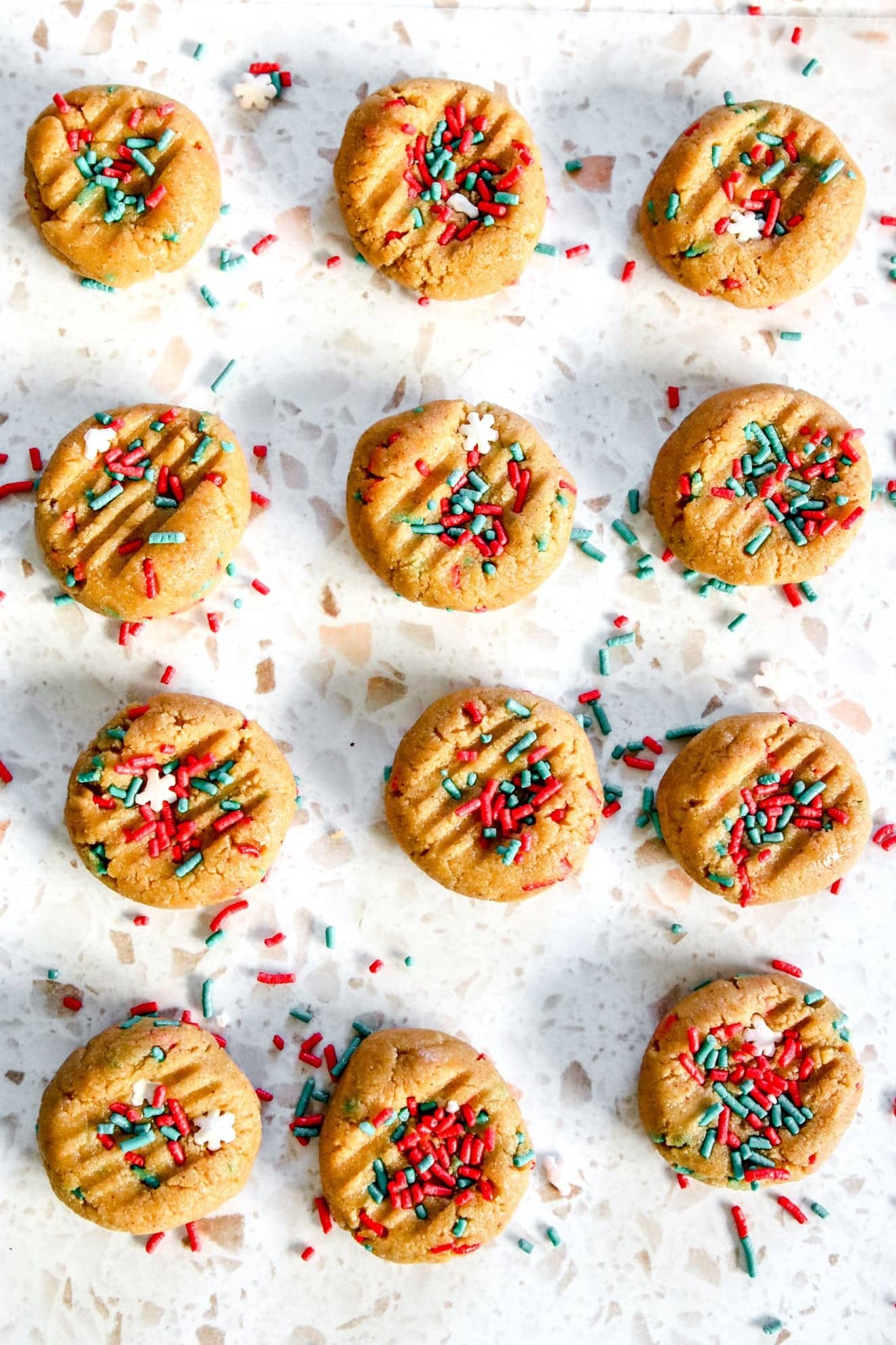 Mini cookies laid on a table with sprinkles. 