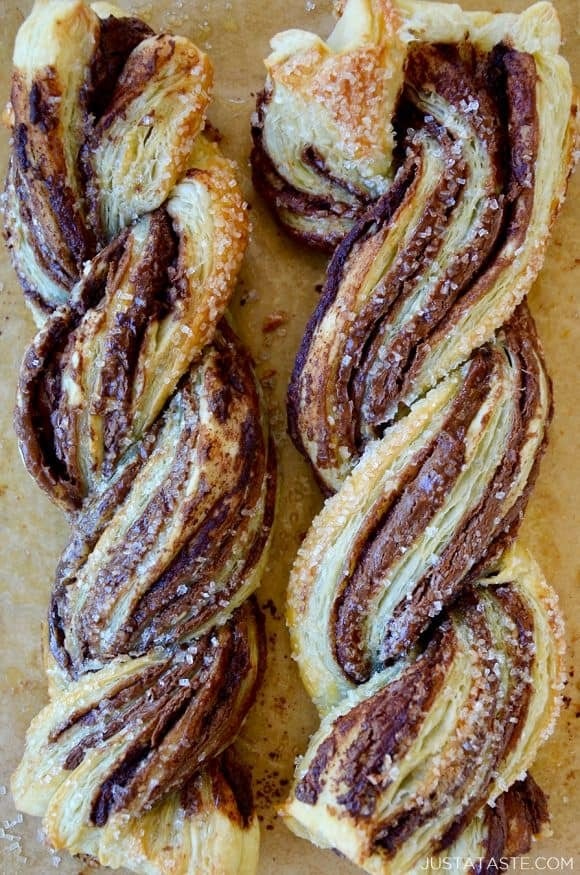 Twisted bread with chocolate spread on top sprinkled with white sugar. 
