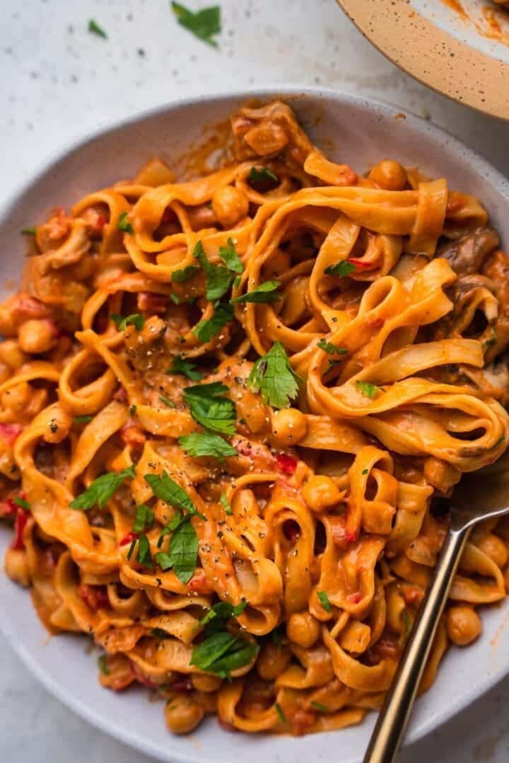 Pasta in orangey sauce with chickpeas, red peppers and chopped parsley. 