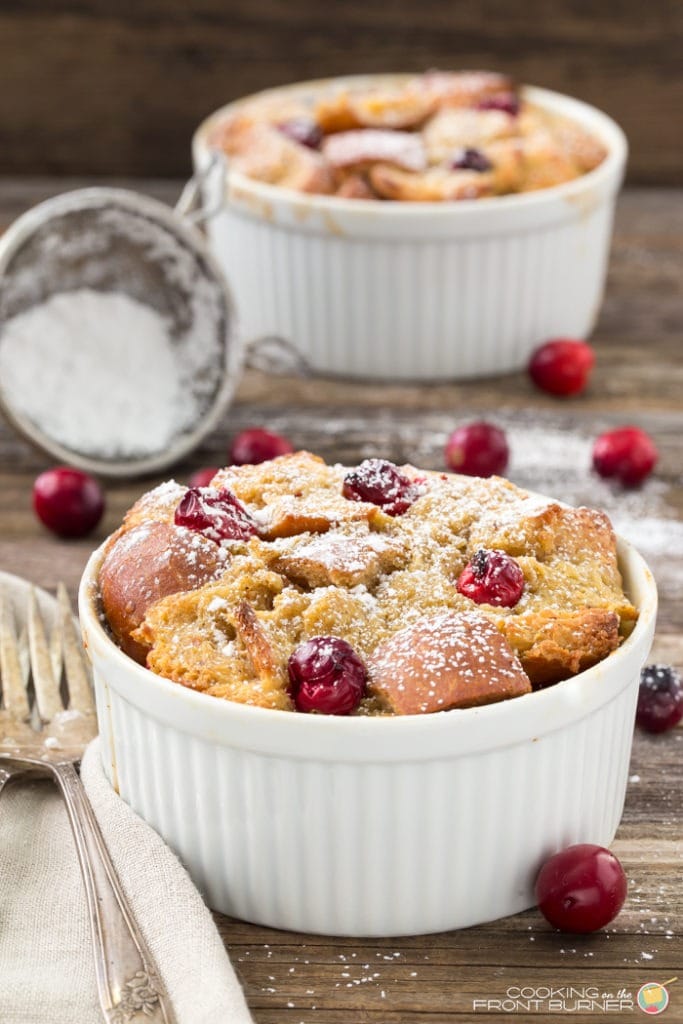 Eggnog French toast in a mug garnished with cranberries and powdered sugar. 