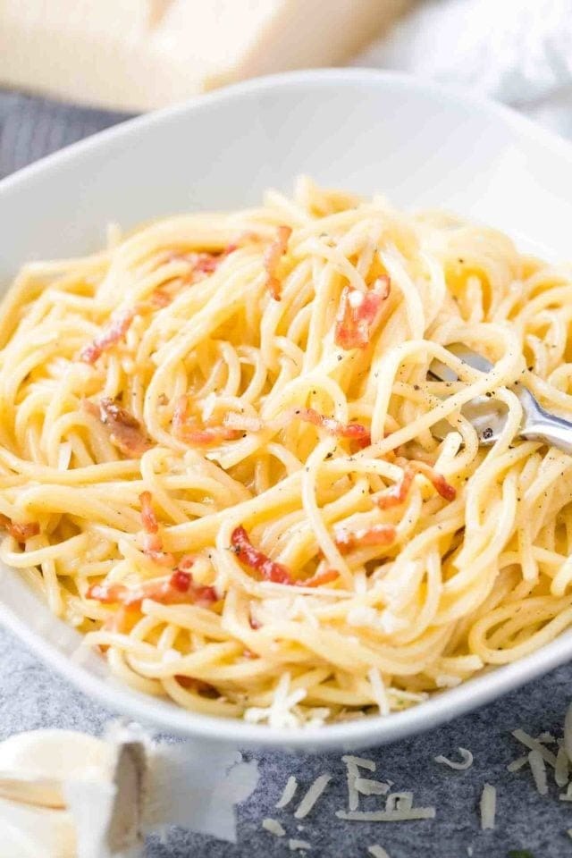 Carbonara pasta serving on a bowl with fork. 