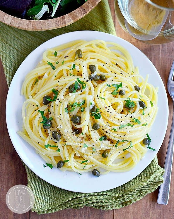 Pasta with garlic butter caper sauce served on a white plate.