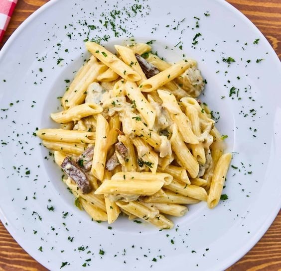 Pasta with truffle cream sauce served on a plate.