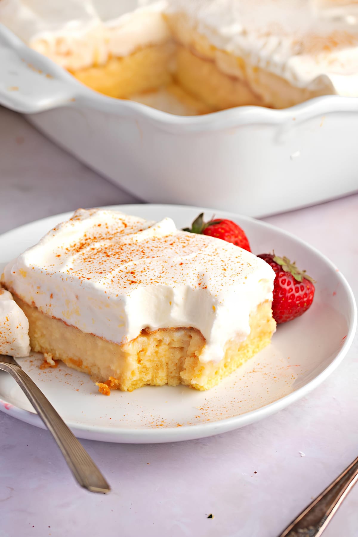 Pastel de Tres Leches (3 Milks Cake) featuring A plate of pastel de tres leches with a fork and strawberries, perfect for indulging in a sweet treat