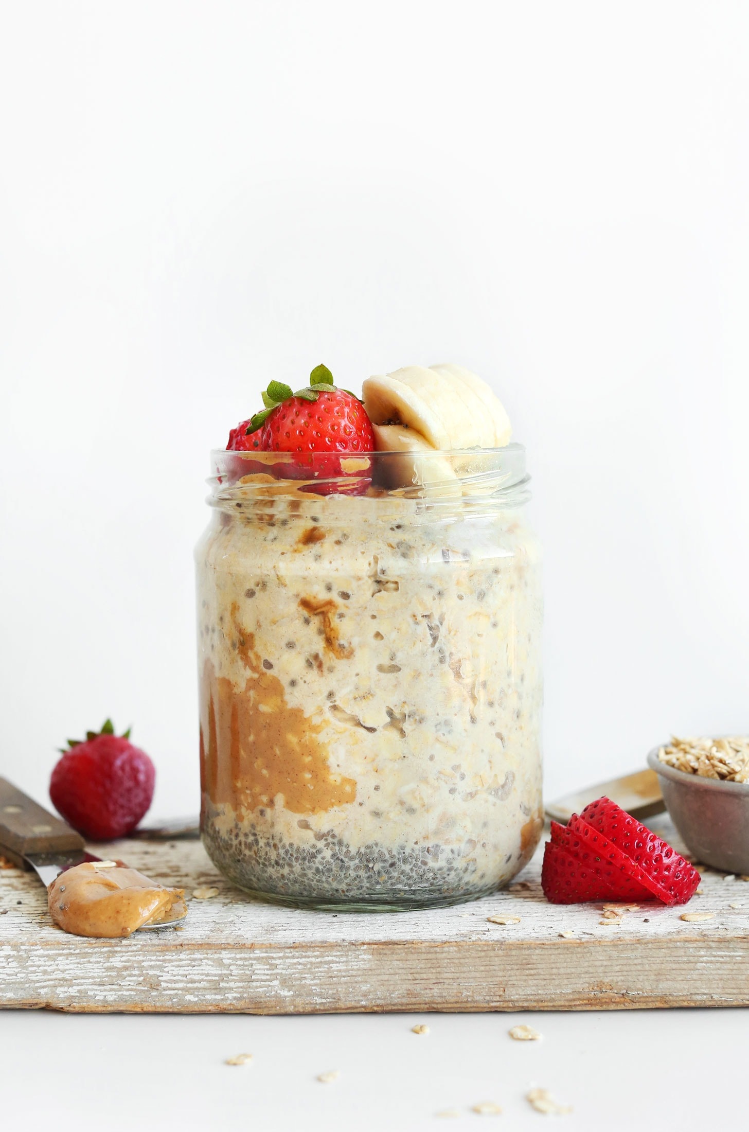 Overnight oats in a mason jar with chia seeds, peanut butter, banana and strawberry.