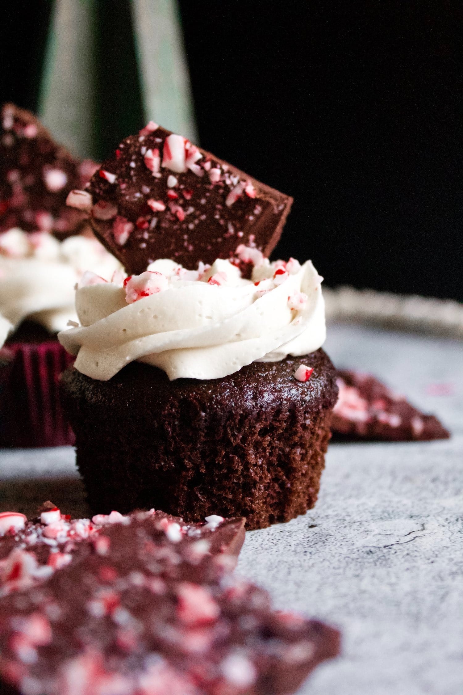 Chocolate cupcakes with frosting and piece of chocolate bark on top. 