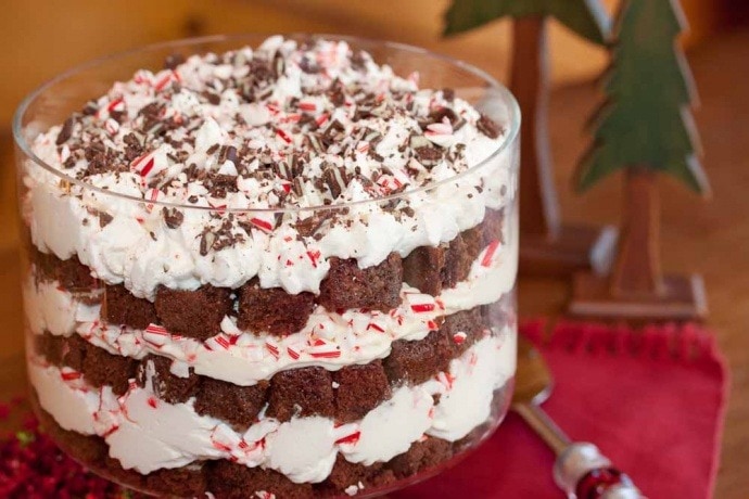 Brownie trifle made with layers of cream and bite size chocolate brownies topped with crushed peppermint candy cane. 