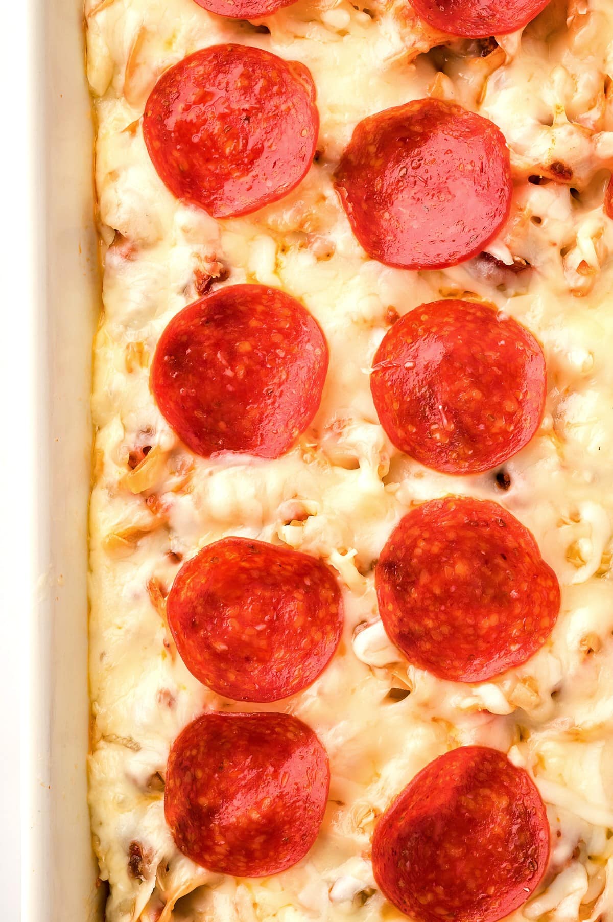Cheesy pepperoni pizza casserole, top view close-up shot