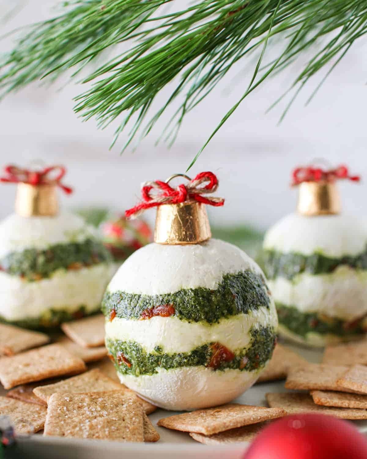 Cheeseballs decorated as ornaments with pesto and sun dried tomato filling. 