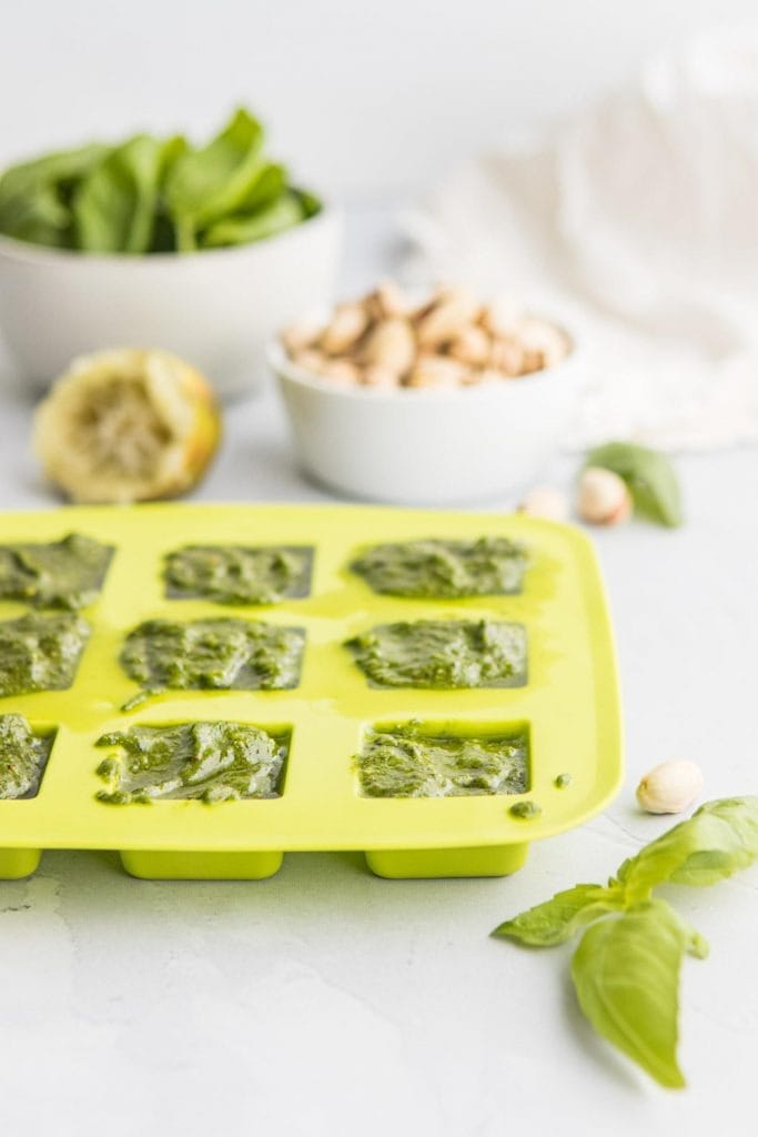Pistachio pasta sauce portions placed on ice cube tray. 