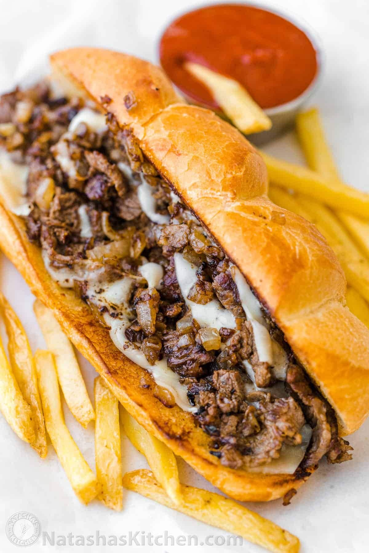 Tender ribeye steak, melted gooey provolone, and caramelized onions hugged by a toasted garlic butter hoagie roll with fries and French dip on the side