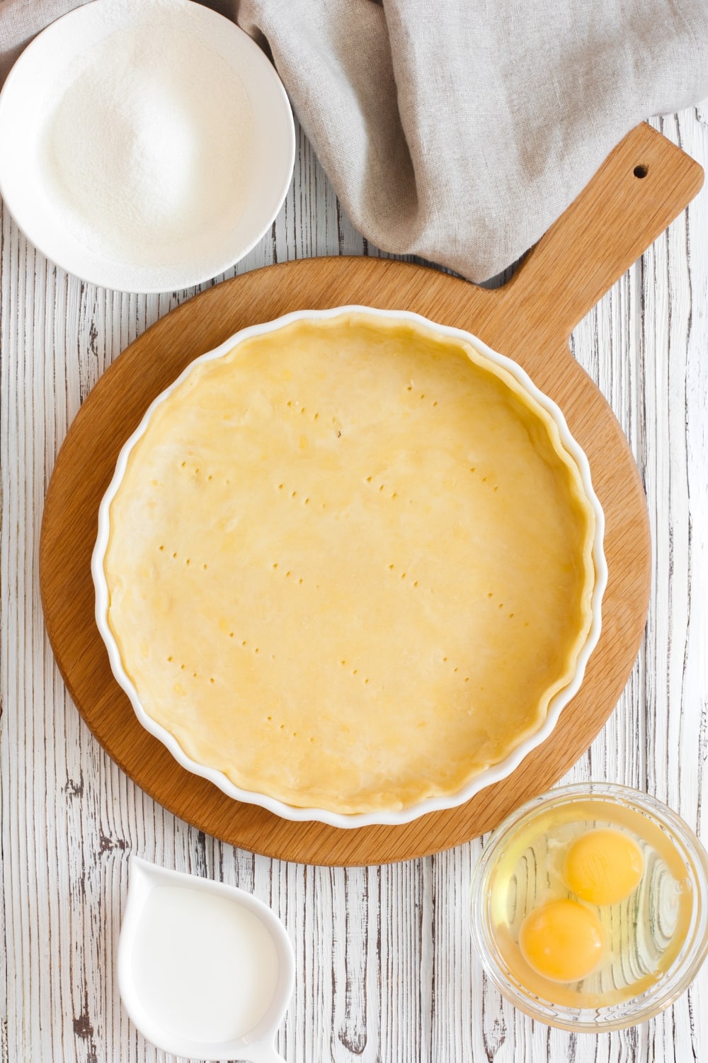Pie crust, egg, milk and flour on a table. 