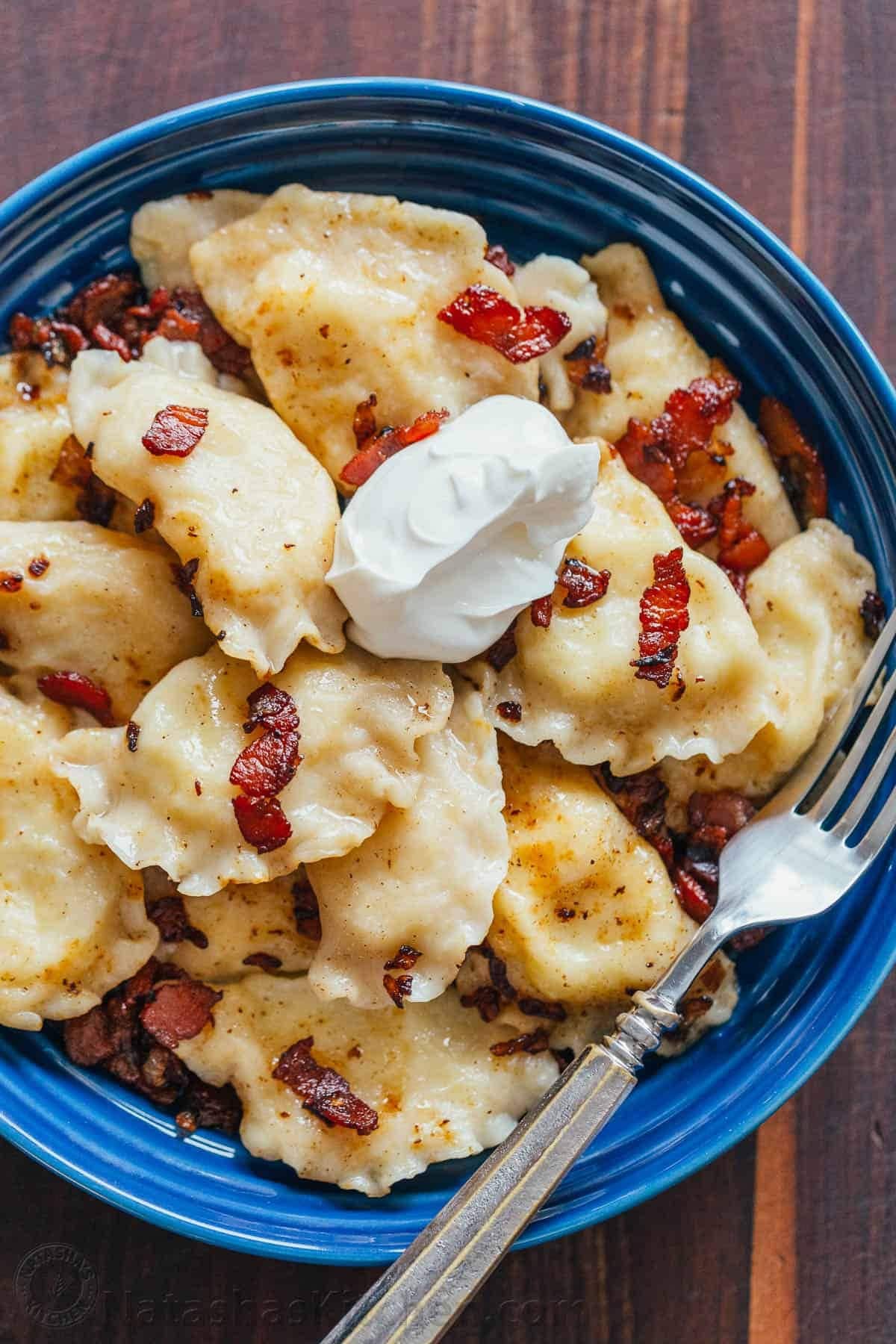 Bunch of potato dumplings with bacon bits on a plate. 