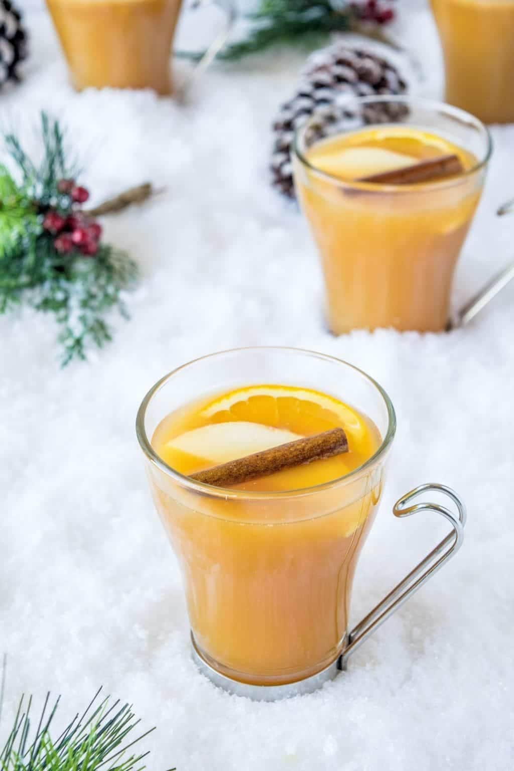 Orange drinks on glass mugs with caramel, orange, and cinnamon.
