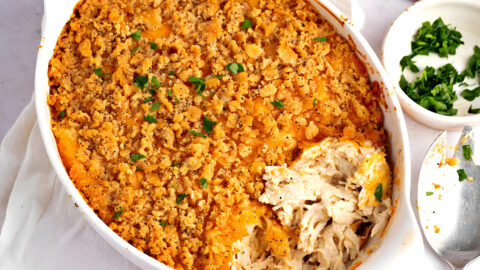 Portion missing of a chicken casserole with poppy seeds.