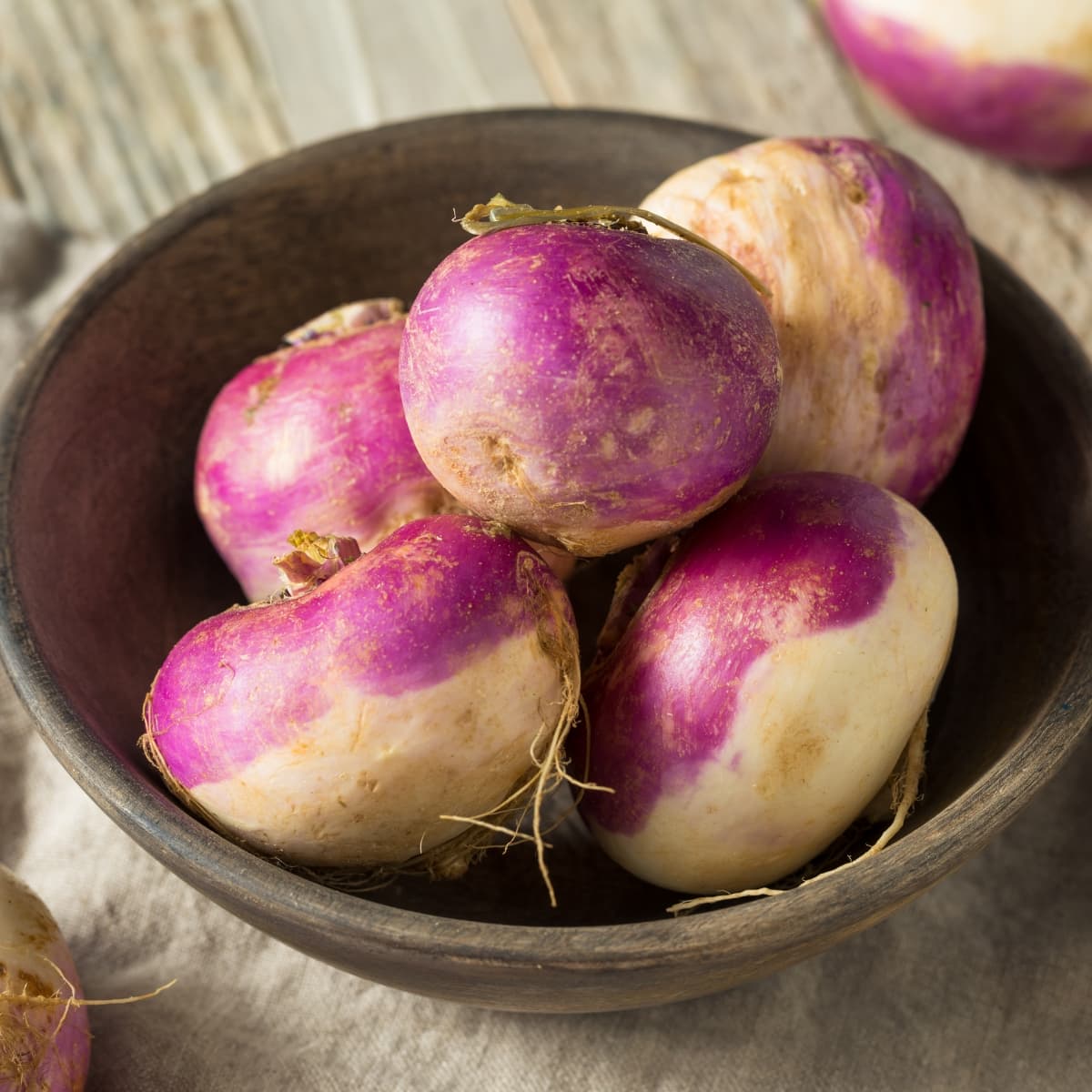 Root vegetable purple turnips on a wooden bowl