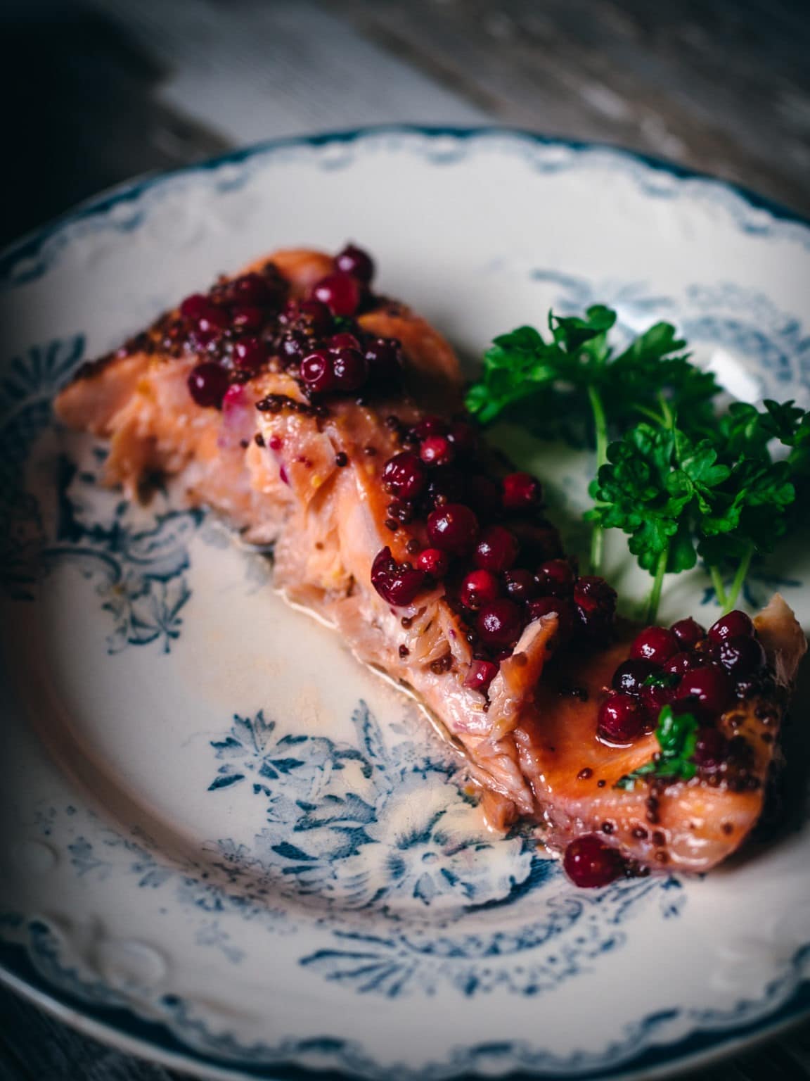 Salmon topped with wild lingonberries and sauce.