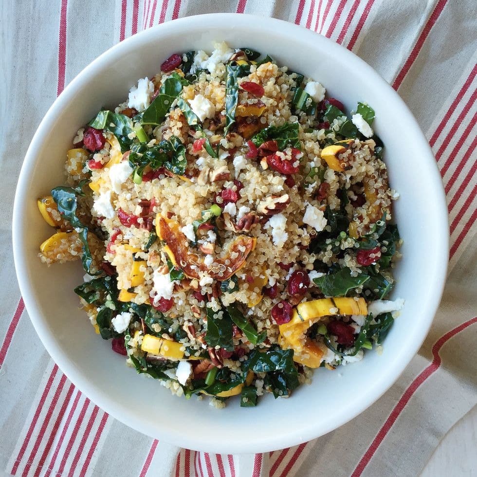 Quinoa salad with roasted squash, dried cranberries, and pecans on a bowl. 