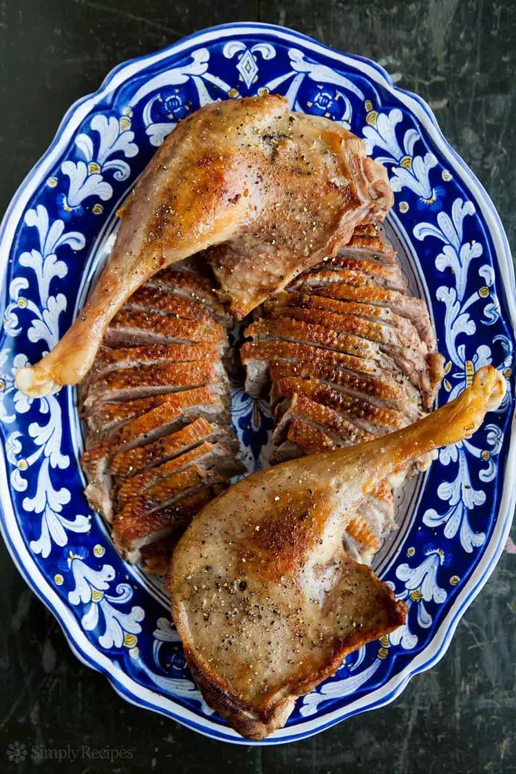 Sliced roasted goose thighs served on a plate. 