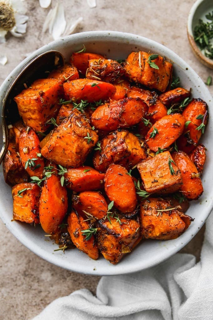 Roasted sweet potatoes and carrots with maple syrup, cinnamon, rosemary, and thyme.