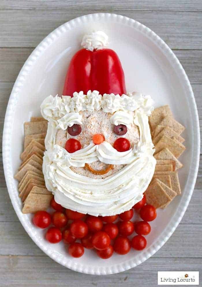 Cheeseball decorated as Santa face with whipped cream served with crackers.