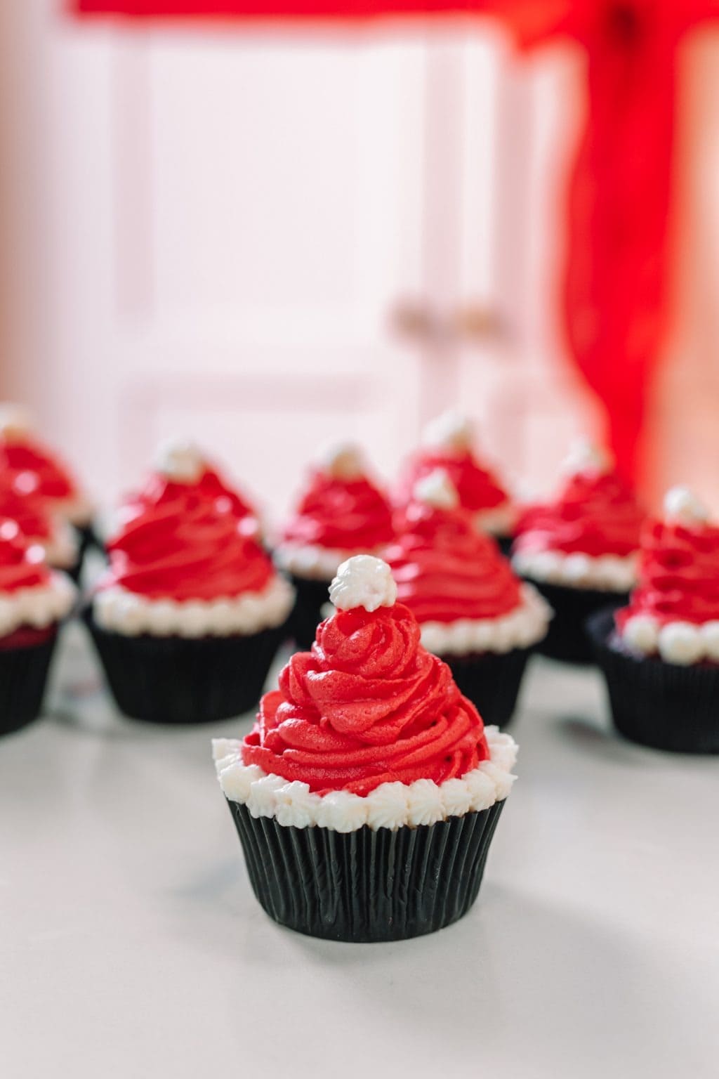 Chocolate cupcake topped with red frosting and  white frosting piping. 