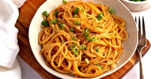 Spicy and Garlicky Noodles with Spaghetti Topped with Green Onions in a Bowl