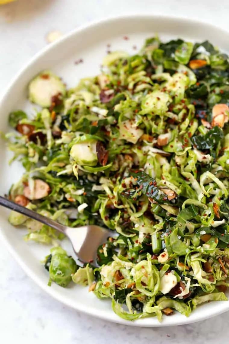 Shaved brussels sprouts salad on a white plate. 