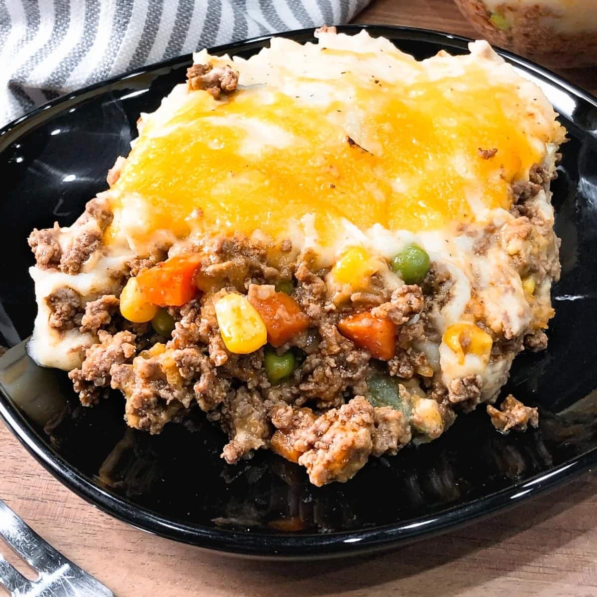A serving of shepherd's pie with cheesy toppings.
