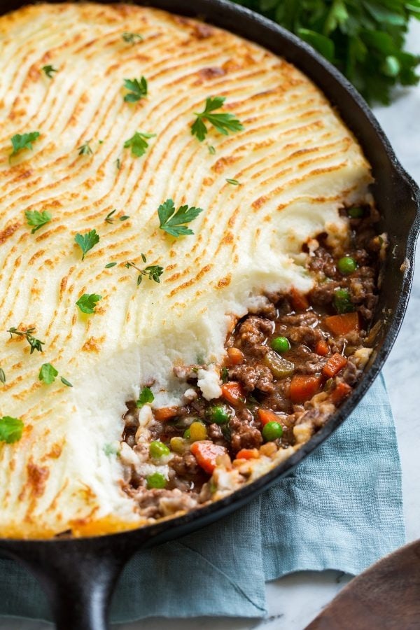 Shepherd's Pie cooked in cast iron pan with  beef, veggies, rich gravy topped with mashed potatoes. 