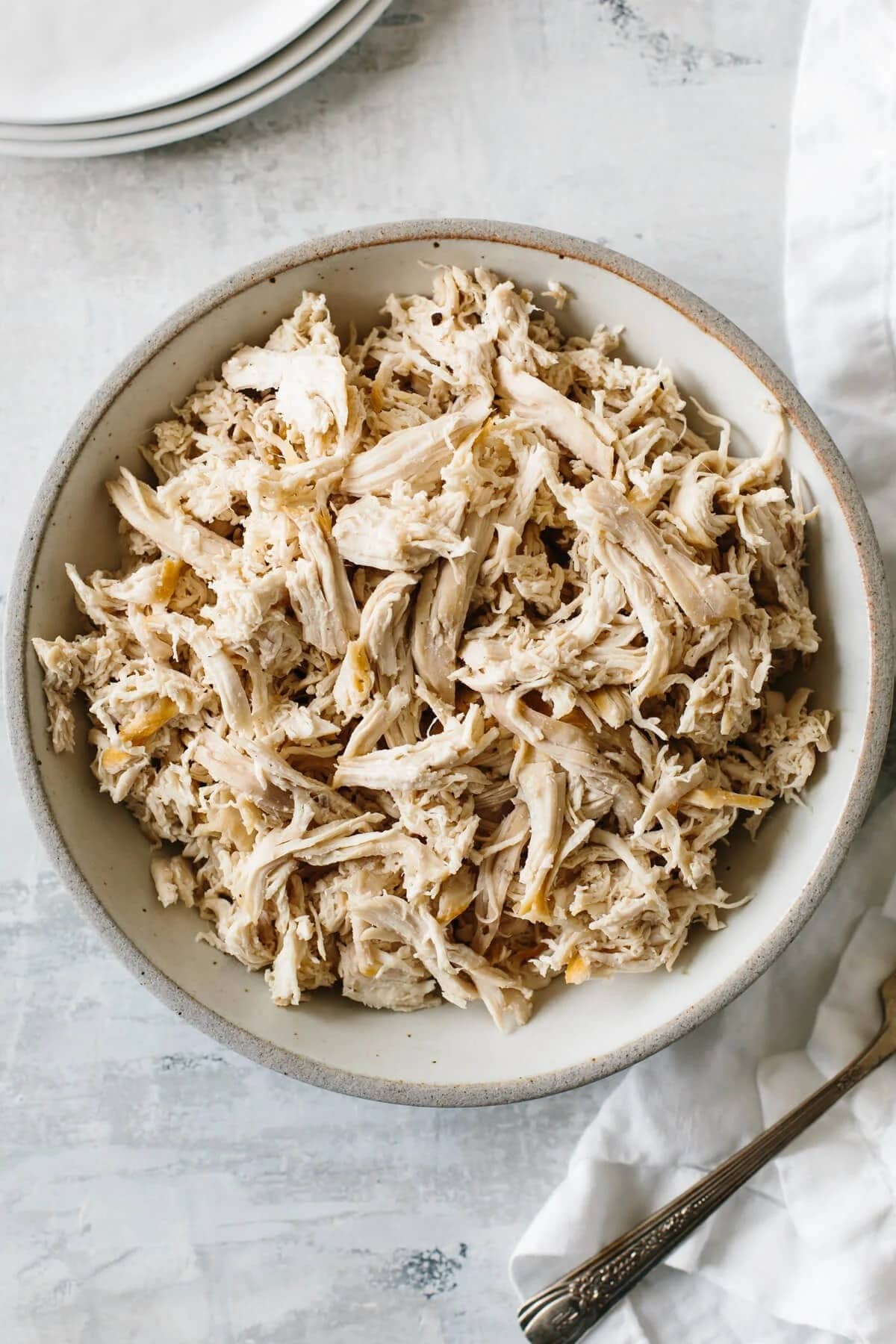 Shredded chicken meat in a white bowl. 