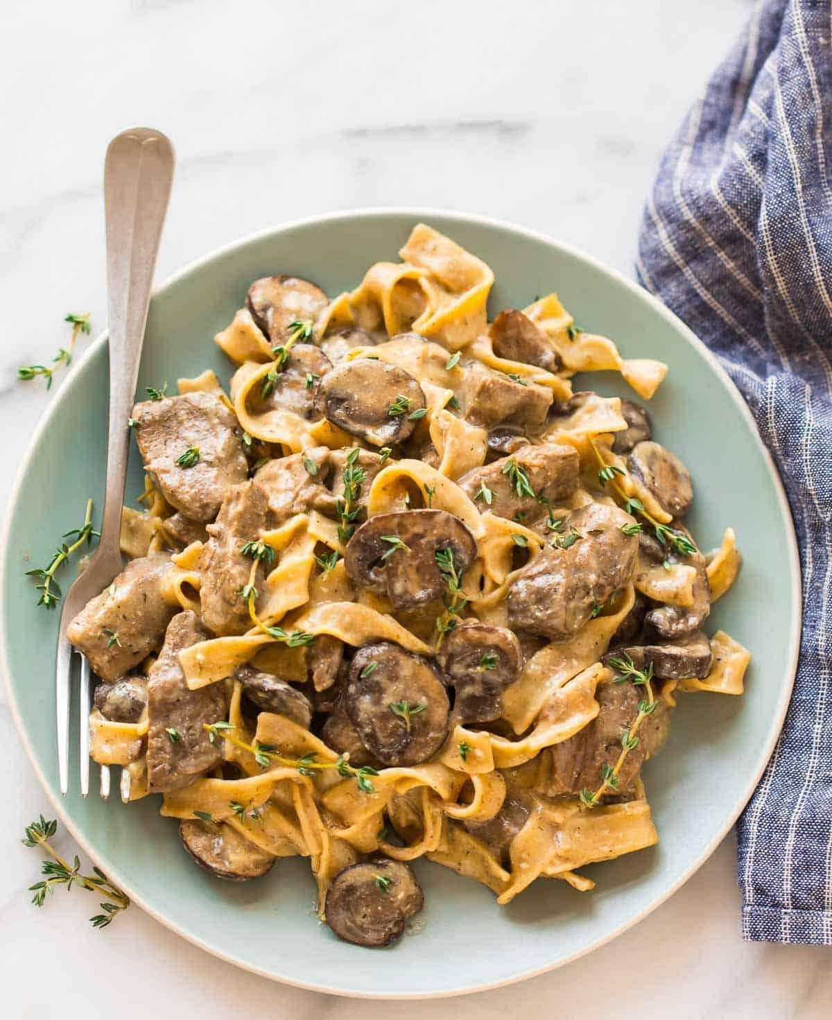 Beef Stroganoff with sliced mushrooms garnished with thyme