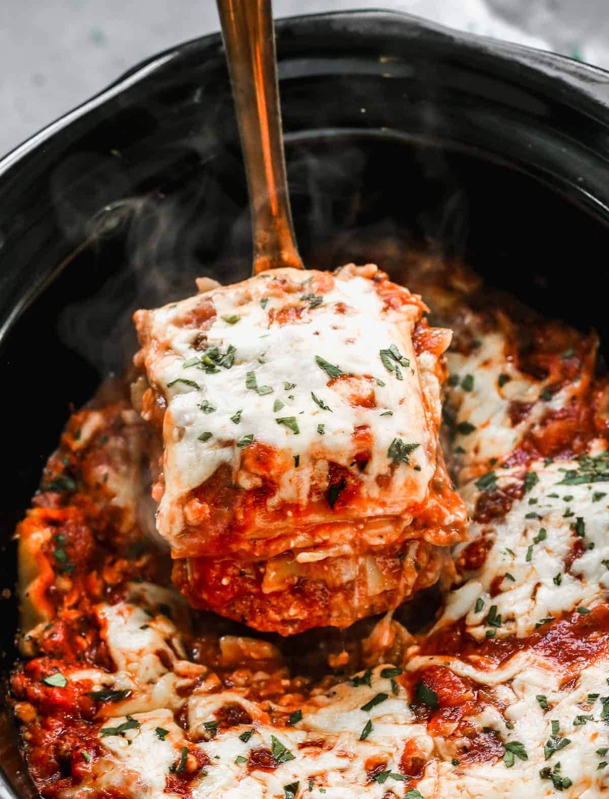Ladle scooping a slice of Lasagna on a slow cooker