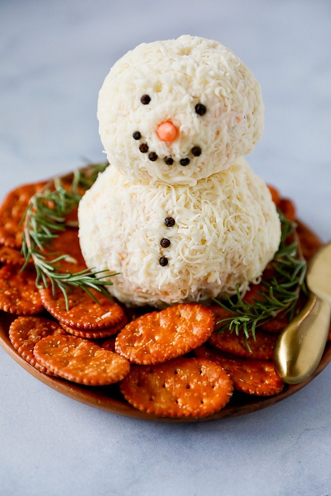 Cheeseballs shaped into snowman served with crackers. 