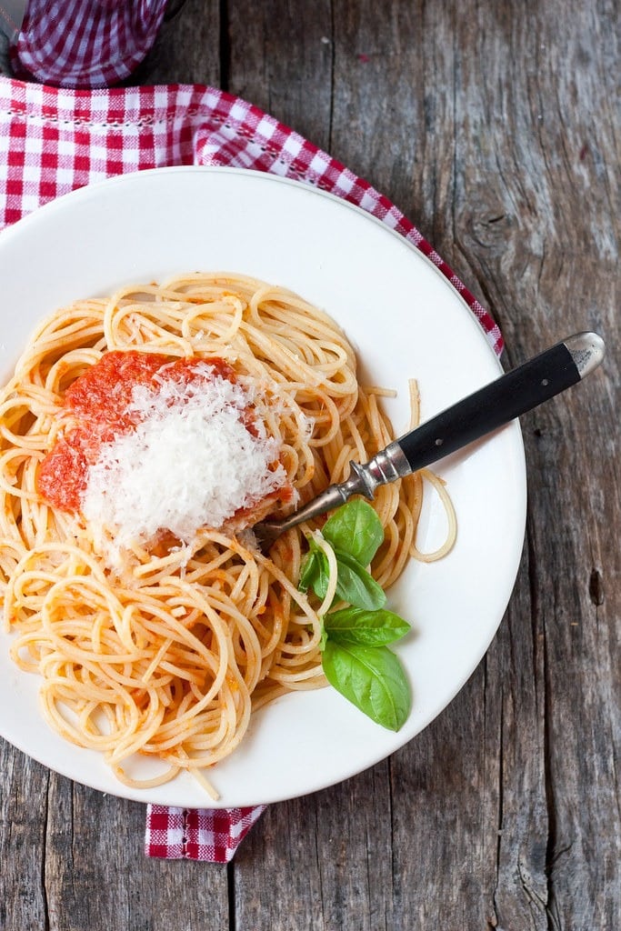 Spaghetti noodles topped with tomato sauce and grated parmesan cheese.