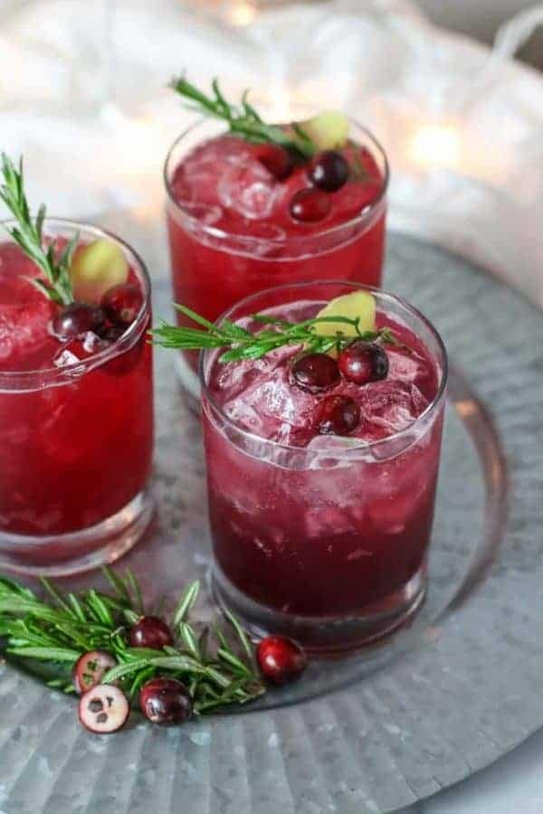 Three glasses of cranberry mocktail with rosemary sprigs