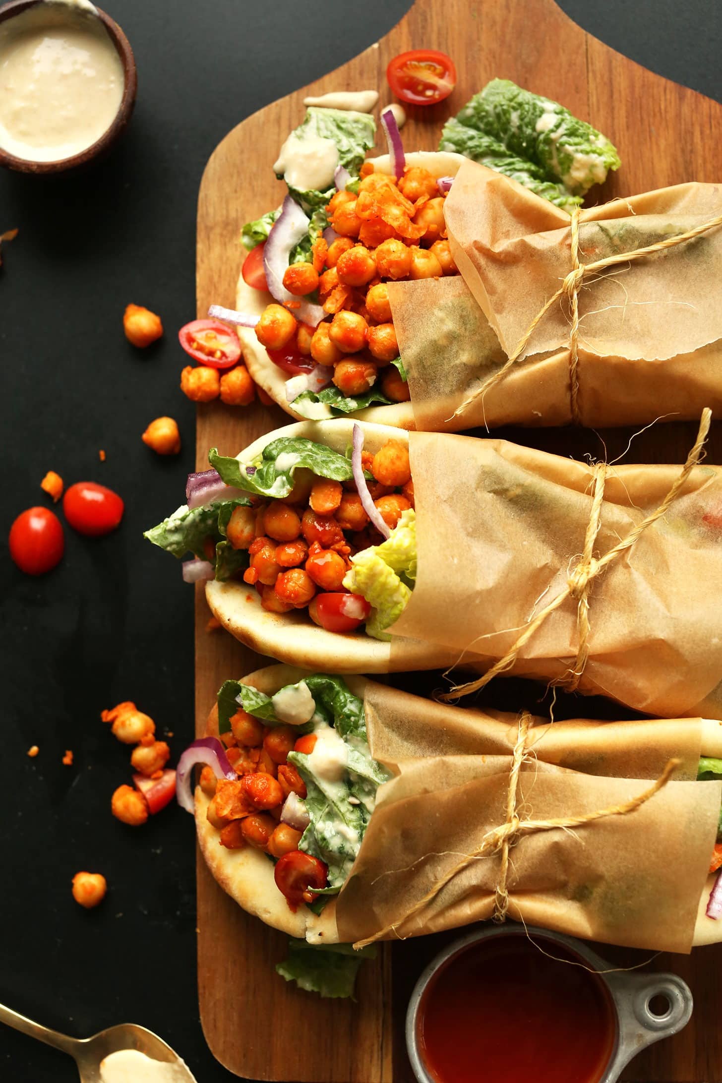 Spiced Chickpea Wraps rope tied with parchment paper on a wooden cutting board