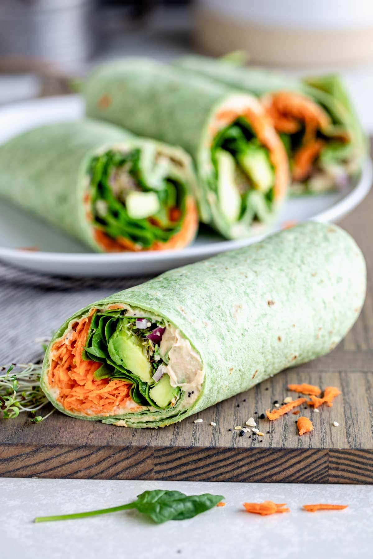 Homemade spinach wrap with hummus, avocados and carrots
