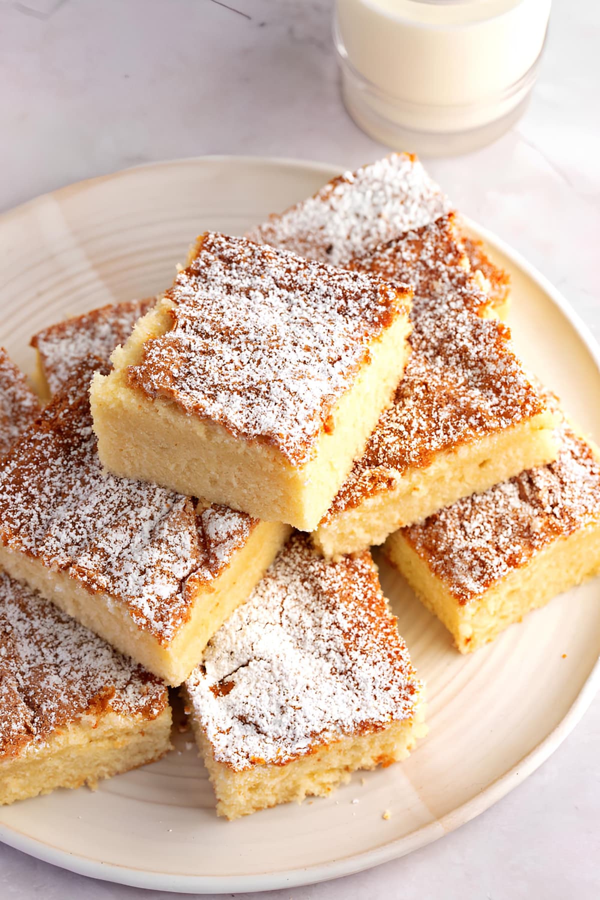 Bunch of hot milk cake bars stacked on plate. 