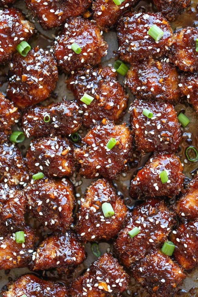 Sticky Garlic Chicken Bites garnished with sesame seeds and chopped spring onions
