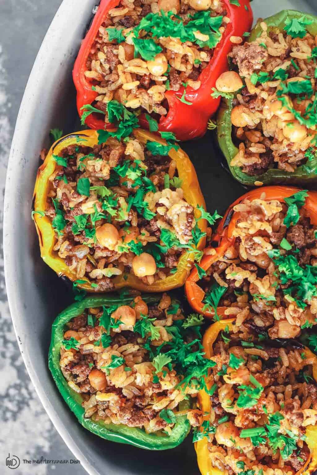 Greek Stuffed Bell Peppers with Rice, Chickpeas, Ground Beef, and Herbs in a Large Casserole Dish