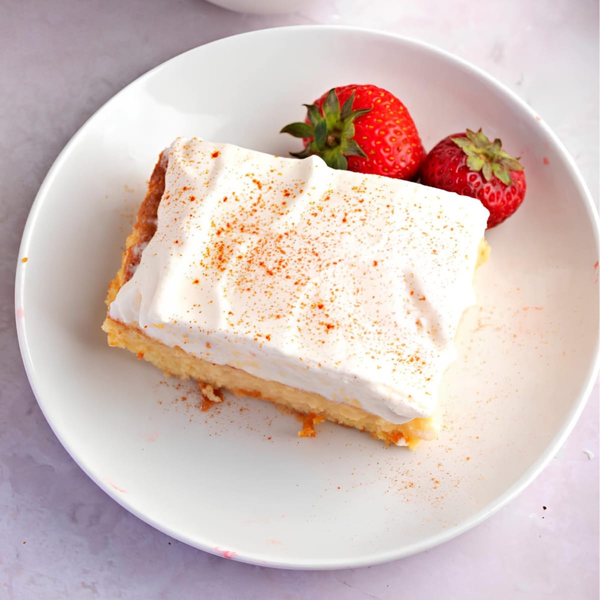 Sweet Pastel de Tres Leches on a Plate Served with Fresh Strawberries