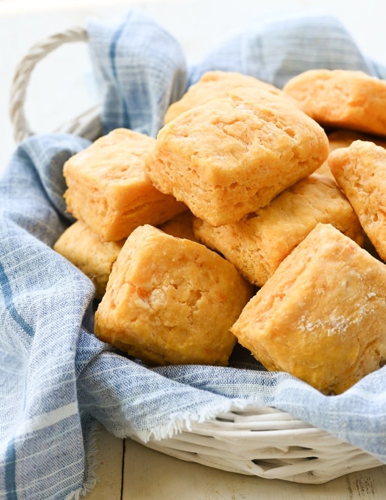 Bunch of sweet potato biscuits on a basket with cloth lining. 