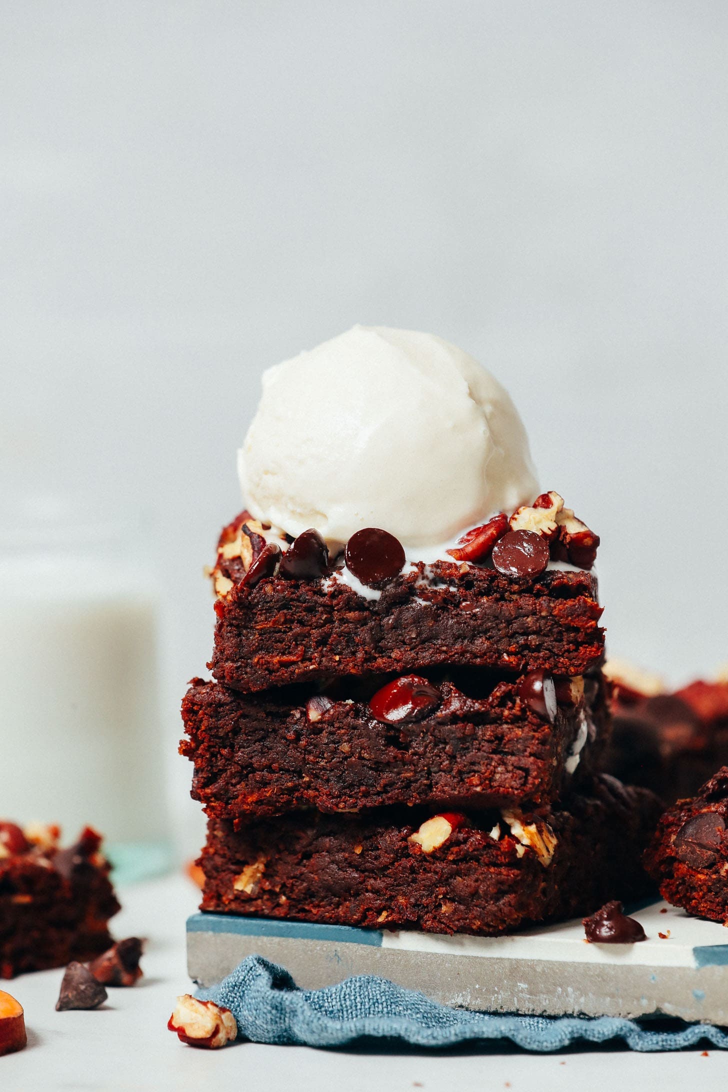 A stack of sweet potato brownies with a scoop of vanilla ice cream on top. 