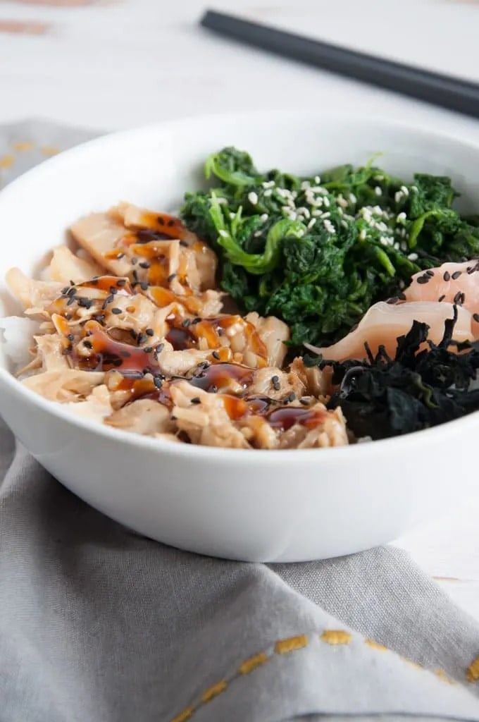 Pulled jackfruit with teriyaki sauce, spinach and dried seaweed, served with rice on a bowl.
