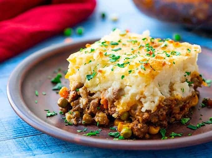 A serving shepherd's pie with ground beef, tender veggies topped with mashed potatoes.