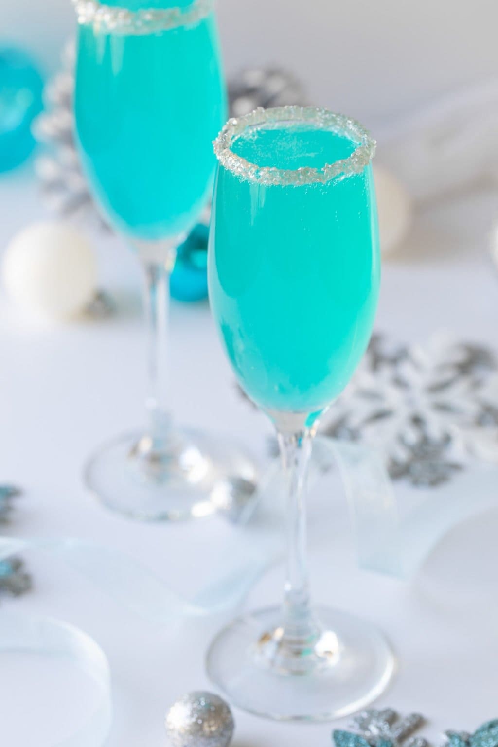Blue cocktails served in sugar-rimmed wine glasses. 