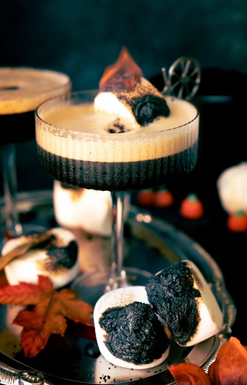 Foamy black Martini cocktail served with toasted marshmallows. 