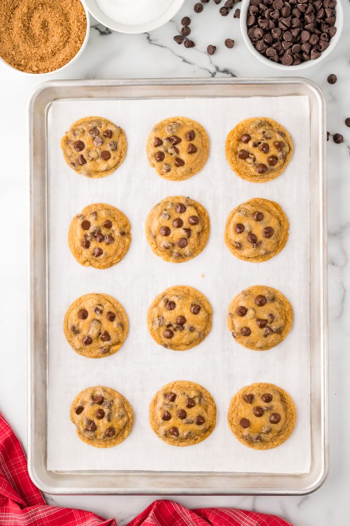 Half-baked chocolate chip cookies on a baking sheet lined with parchment paper.